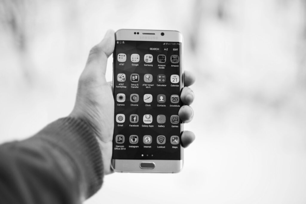 Hand hält Handy mit vielen verschiedenen Apps